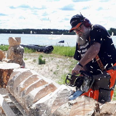 Taiteilija Kari Tykkyläinen veistää moottorisahalla