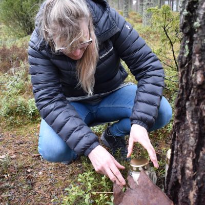 Anna-Leena Suni sytyttää hautakynttilää.