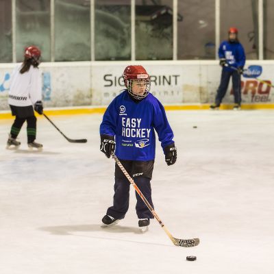 Lapsia pelaamassa jääkiekkoa.