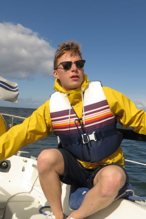 Lucas har ingen aning om hur man seglar, men greppar gärna rodret och ser proffsig ut om någon har en kamera i närheten. Lucas Dahlström seglar iklädd gul regnjacka och flytväst.