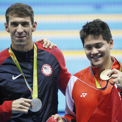 Två simmare med varsin medalj av olika valör.