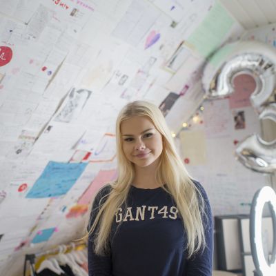 Jennifer Käld huoneessaan, jonka seinät ovat täynnä fanipostia.
