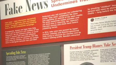 Avdelningen för fake news är flitigt besökt på Newseum. Här en kvkinna frmaför bilden på Donald Trump.