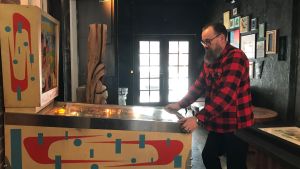 Till verkstaden har Harri Höglund fyndat ett gammalt flipperspel. Harri Höglund spelar på en flipperapparat