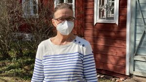 Liisa Gunnelius tycker att det är viktigt att satsa på grundservicen i staden, så att fler vill flytta hit. Kvinna vid ett rött gammalt trähus.