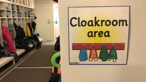 Många tydliga skyltar underlättar inlärningen vid språkbad. Skylt med klädhängare.