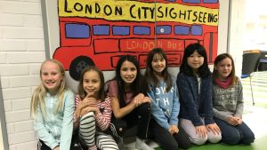 Lova Alin, Oceanne Smeds, Asta Sharma, Neema Hintermeyer, Yiyi Zhang och Lilia Bos går på engelska linjen klass 3-4.De väntar redan på klassresan till London som de får göra när de går på sexan. Skolelever framför teckning av skolbuss.
