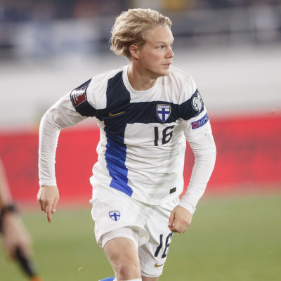 Urho Nissilä springer med boll i en landskamp mot Ukraina.
