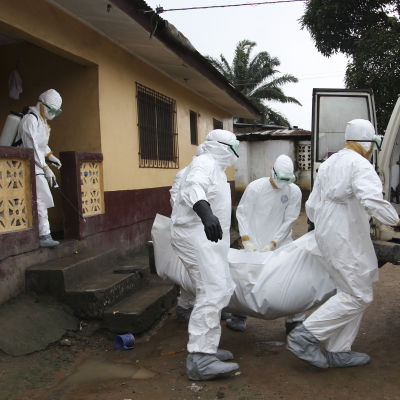 Sjukskötare i Liberia bär ett ebolaoffer.