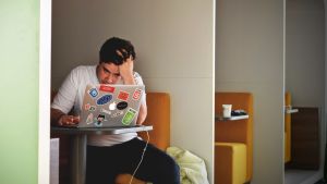 Stress och sömnbrist kan göra dig mer mottaglig för virus. Ung kille och dator