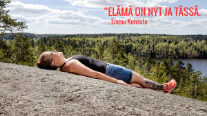 Emma Koivisto makaa kalliolla. Kuvassa teksti: Elämä on tässä ja nyt.