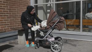 "Jag ser nästan aldrig polisen här i Rosengård", säger Aysha Waleed Shukait. Aysha Waleed Shukait sitter på en bänk utomhus med sin baby i barnvagn.