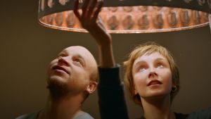Syskonkärlek. Ville och Veera har en nära relation. Syskonen Ville och Veera tittar upp mot en lampa med varmt sken.