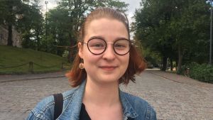 Sara Harju vill att man ska gå och cykla mera. Höjer man biljettpriserna så finns det en risk att människor tar bilen istället, och det är inte bra tycker hon. sara harju i blå jeansjacka och rött hår