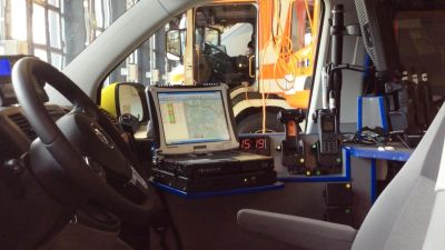 Förarsätet och teknisk utrustning i en fältchefsbil som leder ambulansarbetet. En brandbil syns i bakgrunden.