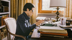 Kino: Pasolini. Mies istuu työhuoneessa työpöydän äärellä.