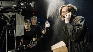Inför en närbild av Jarkka ( Mitja Sirén) i regn. Foto från Sånger vid randen av ett grått hav på Svenska Teatern.