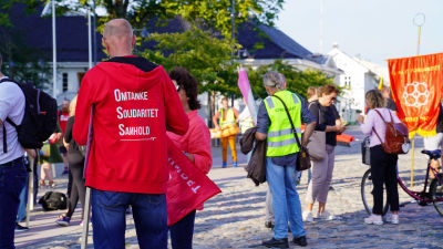 Det står omtanke, solidaritet, samhold på en luvtröja på en demonstrant.