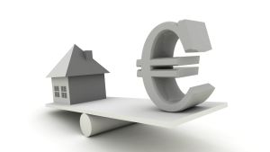 Ett hus och en eurosymbol balanserar på en planka.