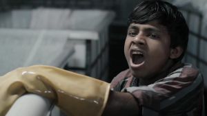 12-årig pojke i textilfabrik i Indien. Ur dokumentären Machines. 12-årig indisk industriarbetare har svårt att hålla sig vaken i textilfabrik.