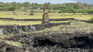 Havet har fått delar av klippväggen att rasa och urholkar klippan under moai-statyn. Statyer på Påskön