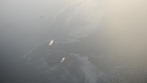 Flygbild av oljeläckan. Några båtar ute på havet bekämpar oljeläckage utanför Utö.