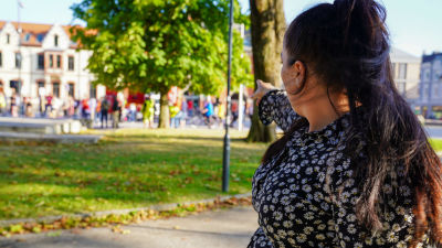 Kaisa Augusta Hansén-Suckow pekar på demonstranter i en park.