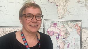 Johanna Wassholm vill leva minimalistiskt och satsar hellre på att resa under sommaren än att spendera tid vid någon stuga. I sommar väntar tågresa längs Transsibiriska järnvägen. johanna wassholm framför en världskarta