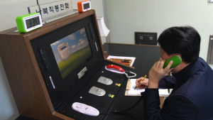 En sydkoreansk regeringstjänsteman kommunicerar med en nordkoreansk kollega över den "heta linjen" i gränsstaden Panmunjom den 3 januari. En sydkoreansk regeringstjänsteman kommunicerar med en nordkoreansk kollega över den "heta linjen" i gränsstaden Panmunjom den 3 januari.