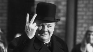 Winston Churchill gör leende segertecknet. Winston Churchill gör leende v-tecknet iklädd sin höga att.