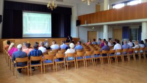 Möten mellan föräldrar kunde ske under friare former. Publik i en festsal. Statistik projicerat på en duk längst framme. Infomöte.