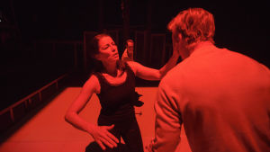 Blodröd thriller. På bilden Kristiina Halttu och Eero Aho, i bakgrunden Markus Järvenpää. Foto från Äidin rakkaus på Nationalteatern.