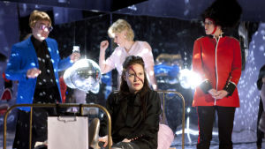 Internerad på Buckingham Palace. Lotta Kaihua som prinsessan Hamlet, omgiven av Elton John ( Hannu Kivioja), prinsessan Diana ( Leea Klemola) och en kunglig väktare (Emmi Parviainen). Foto från Prinsessa Hamlet på Q-teatteri.