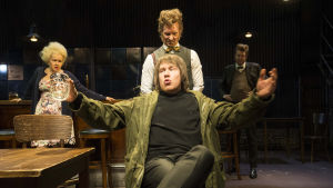 Vad vill främlingen? Sittande Heikki Pitkänen som den gåtfulle Mooney. Foto från Hirttäjät på Nationalteatern.