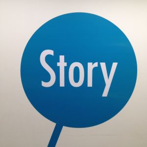 Tohlopin Mediapoliin lattiakoristelusta sininen "varrellinen" pallo jossa lukee valkoisella Story
