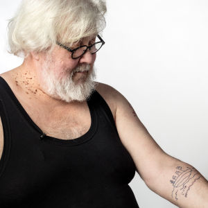Lauri Vuorinen esittelee tatuointejaan studiokuvassa.