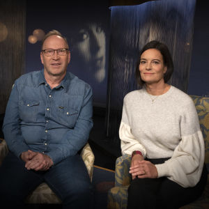 Petri Lampinen ja Hanna Jensen istuvat vierekkäisissä tuoleissa Tohlopin studiossa. 