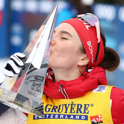 Natalia Neprjajeva firar segern i Tour de Ski 2022 med att kyssa pokalen.