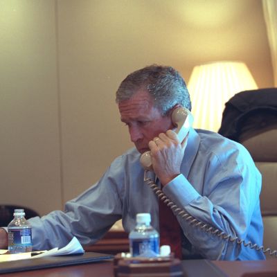 Bild på George W. Bush i blå skjorta. Han ser bekymrad ut och talar i en trådtelefon.