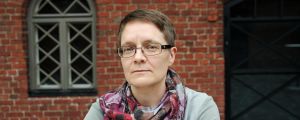 "De kinesiska städerna har ingen makt att ta beslut som går emot regimens linje", säger Anu Tuukkanen från Amnesty. En allvarsam person ser in i kameran. I bakgrunden en tegelvägg.