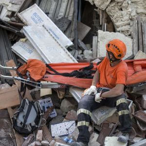 En frivillig räddningsarbetare bland bråte i Amatrice.