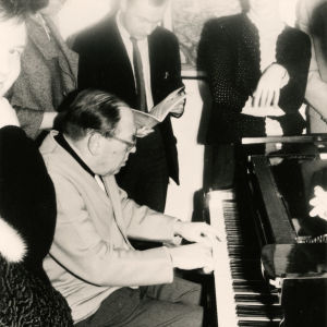 Pianotaiteilja Gerald Moore soittaa opiskelijoiden ympäröimänä.