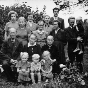 1950-luvun perhepotretti kesäisellä pihamaalla.