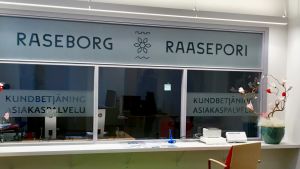 I vanliga fall ska man anmäla sig först. En kundbetjäning där personalen ska finnas bakom ett glas med texten Raseborg Raasepori på glaset. Stolar och litet datorbord syns framför disken. Inga människor på plats.