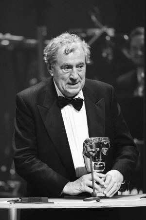 Terry Jones tog emot livsgärningspriset vid BAFTA Cymru Awards 2016. Svertvit bild av Terry Jones i en talarstol med ett pris i handen.