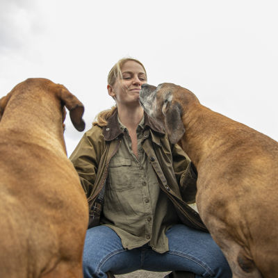 Suontaan kartanon emäntä Ellen Rydbeck koiriensa kanssa kartanon piha-alueella. 