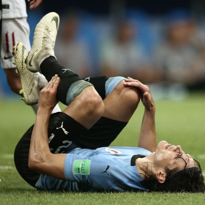Edinson Cavani makaa maassa tuskaisena.