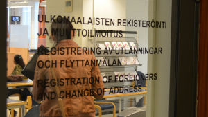 Magistraten i Helsingfors. Vy in genom dörr på vilken det står registrering av utlänningar och flyttanmälan