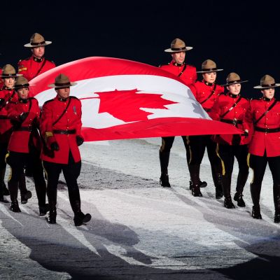9 Kanadan kuninkaallista ratsupoliisia kantaa välissään Kanadan lippua 