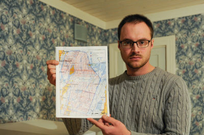 Philip Mannfolk håller upp en karta över Närpes